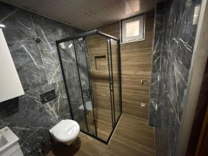 a bathroom with a shower and a toilet at Alpaslan Otel Pansiyon in Antalya