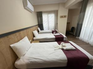 two beds in a hotel room with towels on them at Alpaslan Otel Pansiyon in Antalya