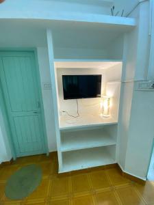 a living room with a tv on a wall at La Ruelle Guest House in Pondicherry +127 photos