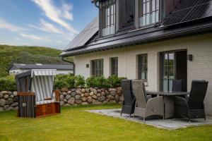 a patio with a table and chairs in front of a house at Doppelhaushälfte Strandgut 4 in Sylt