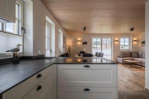a kitchen with white cabinets and a living room at Doppelhaushälfte Strandgut 4 in Sylt +21 photos