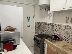 a kitchen with a stove and a refrigerator at Vue de rêve in Cassis
