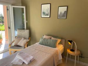 a bedroom with a large bed and a chair at Papiri Beach Summerhouse in Agios Georgios