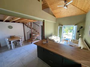 a kitchen and living room with a wooden ceiling at Papiri Beach Summerhouse in Agios Georgios