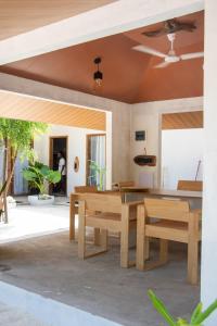 an outdoor patio with wooden benches and a ceiling at Coral stone in Bileffahi