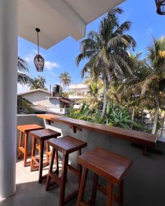 a bar with wooden stools and a view of the ocean at Polelanka guest house in Mirissa