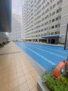 a large swimming pool in a building with tall buildings at Ellain's Cozy Staycation-SMDC Green 2 Residences in Dasmariñas