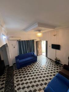 a living room with blue couches and a tv at Funkytee Apartments in Isasi