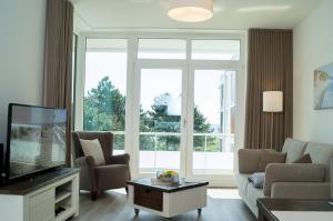 a living room with a couch and a tv at Südkap D-08 in Pelzerhaken +29 photos