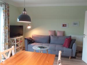 a living room with a couch and a table at Ferienwohnung am Wind mit Dachterasse in Bredstedt