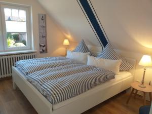 a bedroom with a bed and two lamps and a window at Ferienwohnung am Wind mit Dachterasse in Bredstedt
