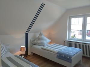 a bedroom with two beds and a window at Ferienwohnung am Wind mit Dachterasse in Bredstedt