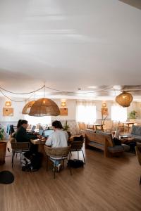 a group of people sitting at tables in a restaurant at WOT Ericeira in Ericeira