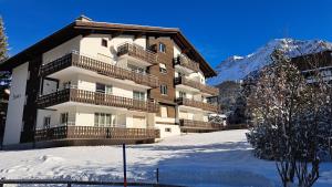 a large building with snow in front of it at Damiez (205 Li) in Lenzerheide