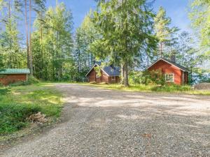 an empty road in front of two houses at Holiday Home Tallukka by Interhome in Pertunmaa