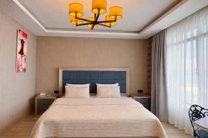 a bedroom with a large bed and a chandelier at Yalı Bahçe Mudanya in Burgaz +60 photos