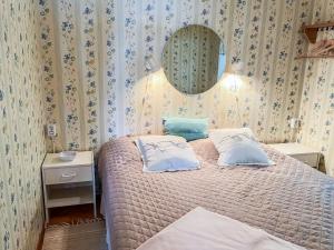 a bedroom with a bed with two pillows and a mirror at Holiday Home Leppäranta by Interhome in Harjula