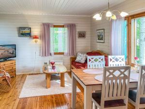 a living room with a table and a couch at Holiday Home Leppäranta by Interhome in Harjula