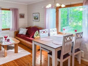a living room with a table and chairs and a couch at Holiday Home Leppäranta by Interhome in Harjula +5 photos