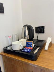 a counter with a coffee maker and cups on it at Mount court munnar in Munnar