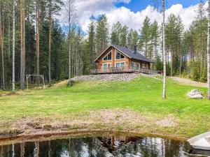 a house on a hill next to a body of water at Holiday Home Inkeri by Interhome in Holiseva