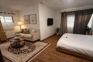 a hotel room with a bed and a couch at The 12th Avenue in Lusaka