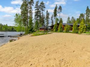 a sandy beach in front of a house at Holiday Home 7152 by Interhome in Kaartilankoski