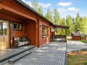 a wooden house with a deck with a grill at Holiday Home 7152 by Interhome in Kaartilankoski +16 photos