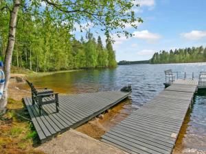a wooden dock with a bench on a lake at Holiday Home 7152 by Interhome in Kaartilankoski