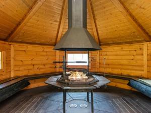 a fireplace in a log cabin with a ceiling at Holiday Home 7152 by Interhome in Kaartilankoski
