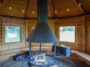 a stove in a log cabin with two windows at Holiday Home Vuorimaja by Interhome in Kylänlahti