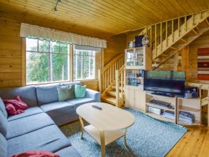 a living room with a couch and a tv at Holiday Home Vuorimaja by Interhome in Kylänlahti