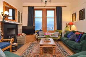 a living room with a couch and a tv at Aldersyde in Tighnabruaich
