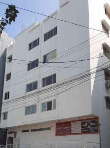 a white building with a sign in front of it at Sukhnidras Dormitory in Hyderabad