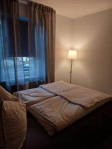a bedroom with a bed with a lamp and a window at FeWo Sasa in Blankenburg