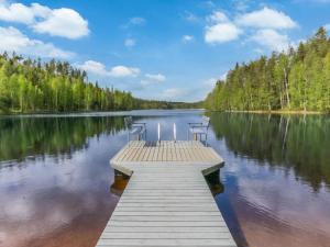 a dock on a lake with two chairs on it at Holiday Home 7734 by Interhome in Kaartilankoski