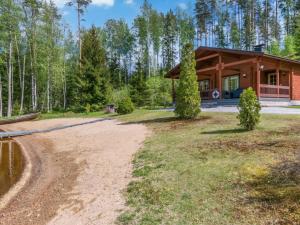 a cabin in the woods with a dirt road at Holiday Home 7734 by Interhome in Kaartilankoski
