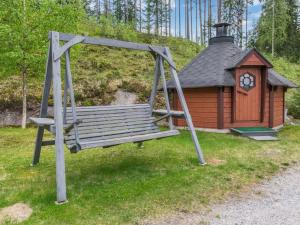 a swing in front of a small building with a clock at Holiday Home 7734 by Interhome in Kaartilankoski +15 photos