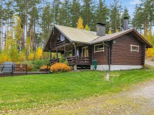 a log cabin with a grassy yard at Holiday Home Rantalaukka by Interhome in Haapiala