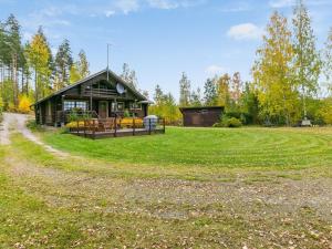 a log cabin in the middle of a field with a dirt road at Holiday Home Rantalaukka by Interhome in Haapiala +28 photos