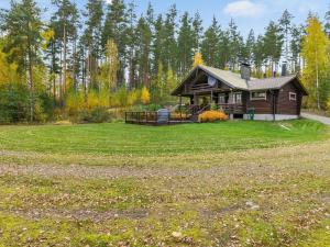 a log cabin in the middle of a grass field at Holiday Home Rantalaukka by Interhome in Haapiala