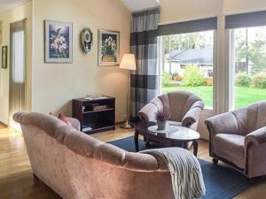 a living room with two couches and a table at Holiday Home Merivanamo by Interhome in Haukipudas