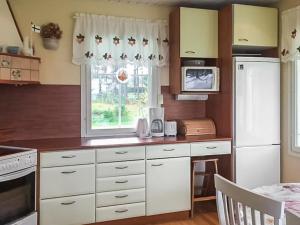 a kitchen with white cabinets and a window at Holiday Home Merivanamo by Interhome in Haukipudas