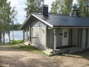 a small house sitting next to a body of water at Holiday Home Varvali by Interhome in Lahdenkylä
