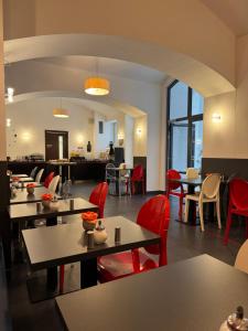 a dining room with tables and red chairs at Red & Blue Design Hotel Prague in Prague