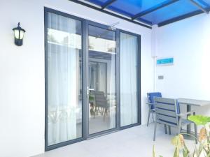 a room with sliding glass doors with a table and chairs at Velaa Dhigurah in Dhigurah