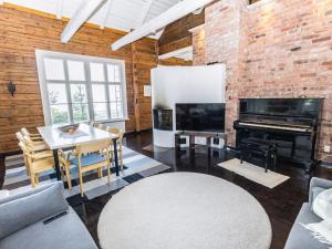 a living room with a piano and a table at Holiday Home Säikkäranta by Interhome in Oulunsalo