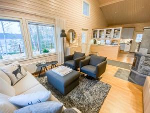 a living room with a couch and chairs and a fireplace at Holiday Home Villa sipilä by Interhome in Savonranta