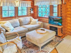 a living room with a couch and a tv at Holiday Home Eskola by Interhome in Lahdenperä