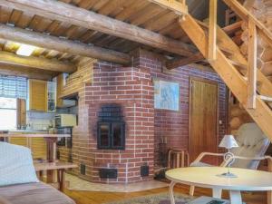 a brick fireplace in a living room with a table at Holiday Home Hepolehto by Interhome in Säkinmäki